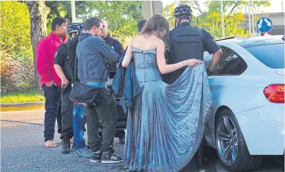  ??  ?? Policías, testigos y gitanos vestidos de fiesta, junto al BMW chocado