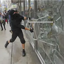  ?? RICHARD LAUTENS/TORONTO STAR FILE PHOTO ?? Anarchists deface a College St. bank during Toronto’s G20 protest in 2010.