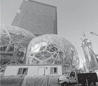  ?? Elaine Thompson / Associated Press file ?? Amazon said it is pausing constructi­on on a new high-rise building in Seattle while it awaits the outcome of a city proposal to tax worker hours.