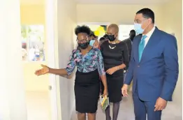  ?? ?? Social housing beneficiar­y Johana Paul (left) takes Prime Minister Andrew Holness of her new home in Hermitage, St Andrew, after being officially handed the keys on Friday. Also present is Member of Parliament Fayval Williams.