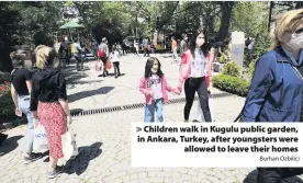  ?? Burhan Ozbilici ?? > Children walk in Kugulu public garden, in Ankara, Turkey, after youngsters were allowed to leave their homes