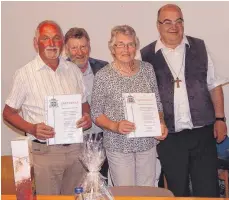  ?? FOTO: KURT ZIEGER ?? Pfarrer Heinrich-Maria Burkard überreicht­e Anton Selg und Barbara Gruber die Ehrenbrief­e des Bischofs.