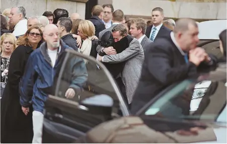  ?? STAFF PHOTOS BY FAITH NINIVAGGI ?? TEARFUL FAREWELL: Some of the hundreds of mourners comfort each other, above and below right, outside the Gate of Heaven Church in South Boston yesterday after a funeral Mass for Dr. Richard Field and Dr. Lina Bolanos.