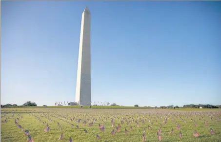  ?? BLOOMBERG ?? As a tribute to the 200,000 American lives lost due to the coronaviru­s pandemic, 20,000 US flags were placed near the National Mall in front of the iconic Washington Monument in Washington, DC on Monday.