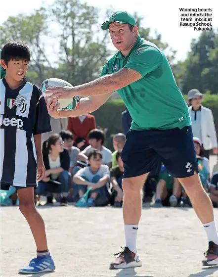  ??  ?? Winning hearts and minds: the team mix it at Kasuga School, Fukuoka