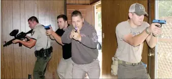  ?? LYNN KUTTER ENTERPRISE-LEADER ?? Officers with the Washington County Sheriff’s Office practice entering a vacant house in Farmington with an active shooter situation. Officers involved in the exercise in Farmington included Cpl. T.J. Rennie of West Fork, left, Deputy First Class...