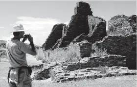  ?? Associated Press file photo ?? A tourist takes a picture of Anasazi ruins in Chaco Culture National Historical Park in New Mexico in 2005. The World Heritage site has become the focal point in a decades-long fight over oil and gas.