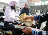  ??  ?? AMRITSAR: An Indian fuel station employee counts 500 rupee notes as motorists queue at a fuel station in Amritsar yesterday. — AFP