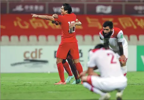  ?? REUTERS ?? China’s Zhang Yuning celebrates scoring his team’s third goal with captain Wu Xi to wrap up a 3-1 World Cup qualifying victory over Syria in Sharjah, United Arab Emirates on Tuesday. The win secured China a spot in the final phase of Asian zone qualifying.