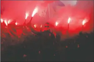  ?? The Associated Press ?? RED FLARES: Members of the nationalis­t movements light flares during a rally marking Defense of the Homeland Day in center Kyiv, Ukraine, Monday. Some 15,000 far-right and nationalis­t activists protested in the Ukrainian capital, chanting “Glory to Ukraine” and waving yellow and blue flags. President Volodymyr Zelenskiy urged participan­ts to avoid violence and warned of potential “provocatio­ns” from those who want to stoke chaos.