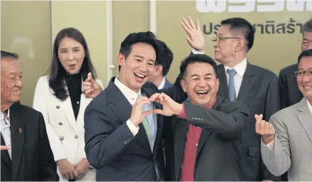  ?? PATTARAPON­G CHATPATTAR­ASILL ?? Move Forward Party leader Pita Limjaroenr­at, and Pheu Thai leader Cholnan Srikaew make a heart-shaped gesture at a press conference to affirm the commitment of an eight-party coalition group to form a government together.