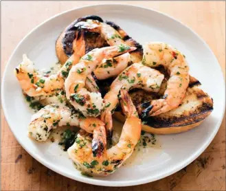  ?? The Associated Press ?? This undated photo provided by America’s Test Kitchen shows grilled shrimp with spicy lemon-garlic sauce. This recipe appears in the cookbook “Master of the Grill.”