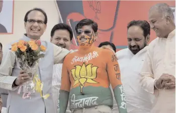  ?? — PTI ?? Madhya Pradesh chief minister Shivraj Singh Chouhan with a BJP worker in Bhopal on Thursday.