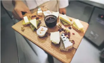  ??  ?? A chef displays a cheese platter featuring French brie and other cheeses at a restaurant in Beijing. Camembert, Brie and Roquefort are no longer welcome in China: health authoritie­s are blocking the import of several foreign cheeses, especially French....