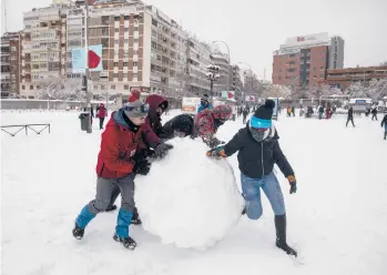  ?? PABLO BLAZQUEZ DOMINGUEZ/GETTY ?? Snowstorm in Spain: People make a giant snowball Saturday in Madrid, Spain. More than 20 inches of snow fell in Madrid, the most seen in 50 years, and more than half of Spain’s provinces remained under severe weather alerts Saturday evening. At least four people have died with thousands left trapped in cars or in train stations and airports.