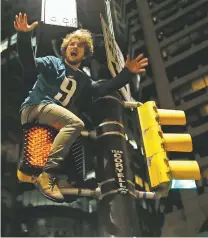  ??  ?? An Eagles fan celebrates Sunday atop a traffic signal in downtown Philadelph­ia. The hydraulic fluid applied in advance by city workers to prevent people from climbing the poles proved ineffectiv­e.