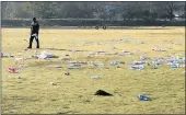  ??  ?? DISGUSTING: A worker surveys the litter left on the Sandringha­m field after a CHDM event