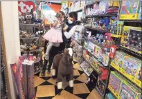  ?? Ned Gerard / Hearst Connecticu­t Media ?? Mark Chiarcossi lifts his daughter, Grace, onto a toy horse at Funky Monkey Toys & Books in Greenwich on Friday. Local shops in Connecticu­t saw an increase in customers on the popular shopping day known as Black Friday.