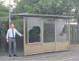  ??  ?? Councillor Brian Thomson at the vandalised shelter.