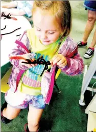  ?? PHOTO SUBMITTED ?? Whitlee Sallee plays with a pipe-cleaner spider during Teen Night at McDonald County Library.