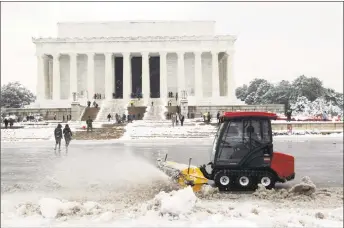  ?? Jose Luis Magana / Associated Press ?? Park service workers clean the snow outside of Lincoln Memorial, during a snowstorm Sunday, as a partial government shutdown stretches into its third week at Capitol Hill in Washington.