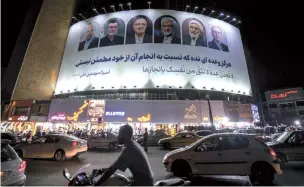  ?? AFP-Yonhap ?? Vehicles pass a billboard displaying the faces of the six candidates running in the upcoming Iranian presidenti­al election, in Valiasr Square, Tehran, Iran, Monday.