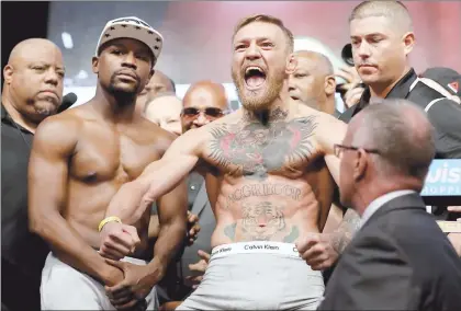  ??  ?? Conor McGregor, campeón ligero de la UFC, grita frente a su rival Floyd Mayweather júnior durante el pesaje oficial de cara a su combate de esta noche en el T-Mobile Arena ■ Foto Afp