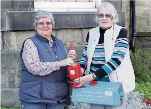  ??  ?? ●● Bollington Town Mayor, Councillor Angela Williams, buys the first poppy in this year’s appeal from Poppy Appeal organiser Anne Cave