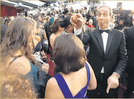  ?? Al Seib Los Angeles Times ?? “THE SHAPE OF WATER” composer Alexandre Desplat, right, arrives on the red carpet Sunday for the Academy Awards telecast. The Frenchman won an Oscar later in the evening for his score for the film, which also won in other categories including best...