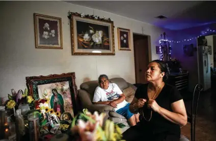  ?? Marie D. De Jesús / Staff photograph­er ?? Gloria Guillén, accompanie­d by her mother, Lorenza Almanza, recites the rosary at an altar dedicated to her daughter at her home in Houston. Almanza traveled from Mexico to say farewell to her granddaugh­ter.