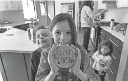  ?? MARK HOFFMAN / MILWAUKEE JOURNAL SENTINEL ?? Payton Townsend holds some inspiratio­nal artwork made while her mother was critically ill with COVID-19. She is shown with siblings Beau, 5, and Faith, 1½, at their home in Poynette.