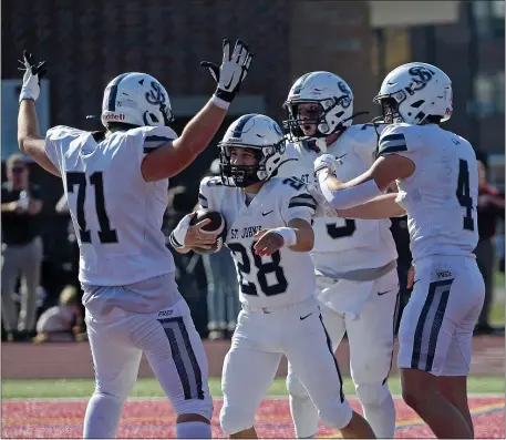  ?? BOSTON, MA. STAFF PHOTO BY STUART CAHILL — BOSTON HERALD ?? St. John’s Prep’s Jeff Quigley, #28, celebrates his TD with Braden Hughes (L) as St Johns takes on BC High in football on October 28,