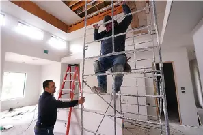  ?? AP Photo/lm Otero ?? Joshua Correa, left, steadies a scaffoldin­g for Samuel as they work at a home under constructi­on Tuesday in Plano, Texas. There are an estimated 2 million fewer immigrants than expected in the United States, helping fuel a desperate scramble for workers in many sectors, from meatpackin­g to homebuildi­ng, that are also contributi­ng to shortages and price increases. Correa has struggled to hire supervisor­s for his work sites, with immigrant job candidates demanding $100,000 yearly pay.