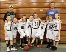  ?? LYNN KUTTER ENTERPRISE-LEADER ?? This third-grade Pee Wee basketball team from Prairie Grove celebrates after their last game of the season. They are coached by Tim Doyle, left, and Austin Simpson. Playing in the league has benefited Pete Dunn, second from left, and his teammates.