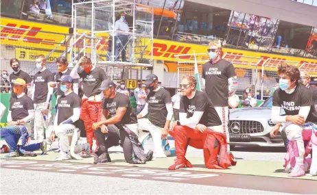  ?? — AFP photo ?? AlphaTauri’s French driver Pierre Gasly (2L), Mercedes’ British driver Lewis Hamilton and Ferrari’s German driver Sebastian Vettel kneel ahead the Austrian Formula One Grand Prix race on July 5, 2020 in Spielberg, Austria in solidarity with the “Black Lives Matter” movement.