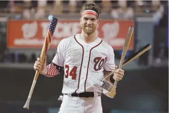  ?? AP PHOTO ?? STAR-RING IN HOMETOWN: Bryce Harper poses with the trophy and a patriotic bat as he celebrates winning the All-Star Home Run Derby last night in Washington.