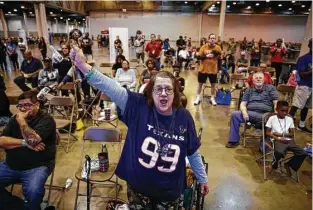  ?? Michael Ciaglo / Houston Chronicle ?? Sporting J.J. Watt’s No. 99, Sarah Norman cheers on the Texans from the shelter at NRG Center, where she has been staying after fleeing from flooding in her apartment. “We’re here together — that’s the only way to get by,” she said. “We’ll get through...