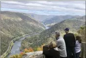  ?? JOHN RABY — THE ASSOCIATED PRESS ?? Visitors look down on the New River Gorge from a national park overlook in October in Grandview, W.VA. Under legislatio­n passed by Congress in 2020, some of America’s most spectacula­r natural settings are getting a makeover. Historic masonry grills have been restored near the Grandview Visitor Center.