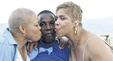  ?? (Photos: Garfield Robinson) ?? Birthday boy Jockey Paul Francis gets double kisses from Aqulla Ottey (left), owner of Get A Pepsi, and Jacqueline Ebanks.