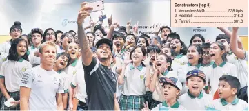  ??  ?? Mercedes driver Lewis Hamilton takes a selfie with students from Maz Internatio­nal School during a Engagement Session with Students at Petrosains Suria KLCC yesterday as teammate Nico Rosberg (left) looks on. — Bernama photo