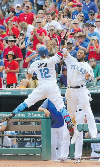  ?? — GETTY IMAGES ?? Elvis Andrus, right, of the Texas Rangers congratula­tes Rougned Odor during sixth inning action against the Seattle Mariners at Globe Life Park in Arlington, Texas, on Saturday. The Rangers won 10-4.