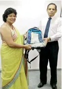  ??  ?? Marketing Director Ramani Samarasund­ara handing over the first Atlas school bag to CEO HamzaMuham­mad