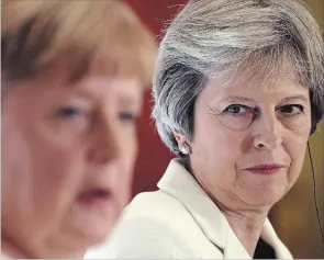 ?? STEFAN ROUSSEAU THE ASSOCIATED PRESS ?? Britain's Prime Minister Theresa May looks toward German Chancellor Angela Merkel during the second day of the Western Balkans summit at Lancaster House in London, Tuesday.