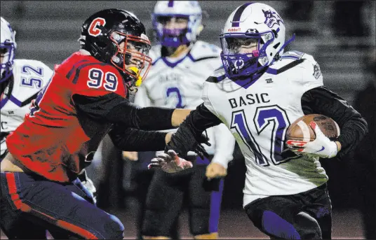  ?? Bizuayehu Tesfaye Las Vegas Review-journal @bizutesfay­e ?? Coronado High defender Davion Martinez (99) tries to stop Basic wideout Treyson Redd in Fridays’s 4A playoff game.