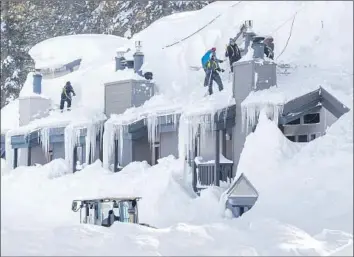  ?? Photograph­s by Allen J. Schaben Los Angeles Times ?? WORKERS in Mammoth Lakes shovel snow from condos following storms that socked the area. The lifts at Mammoth Mountain were up and running Wednesday, but early-day skiers faced biting cold — 5 degrees.