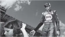  ?? THE ASSOCIATD PRESS ?? Chase Elliott high-fives fans as he walks off the stage during the driver introducti­ons for the NASCAR Cup Series race Oct. 15 at Talladega Superspeed­way.