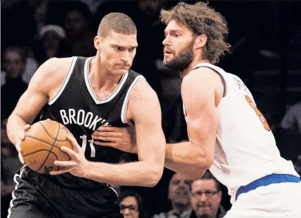  ??  ?? SIBLING RIVALRY: Brook Lopez (left) is defended by his brother, Robin, during the Nets’ 110-104 victory over the Knicks on Wednesday night.