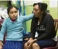  ?? — AP ?? In shock: Survivor Fidelina Lopez being consoled by her daughter Claudia in a shelter in Alotenango.