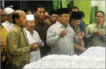  ?? JOS RIZAL/JAWA POS ?? BERDOA: Bupati Saiful Ilah (tengah) bersama Ketua DPRD Sidoarjo Sullamul Hadi Nurmawan (kanan) ikut menerima kedatangan jenazah di Puskesmas Wonoayu, pada Senin dini hari.