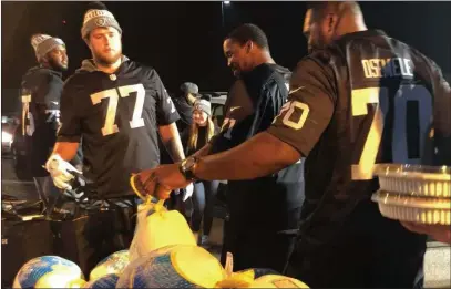  ?? Michael Gehlken ?? Las Vegas Review Journal Raiders offensive linemen, from left, Brandon Parker (75), Kolton Miller (77), Justin Murray (71) and Kelechi Osemele (70) help teammates deliver turkey and trimmings to needy families on Tuesday at the team’s headquarte­rs in Alameda, Calif.